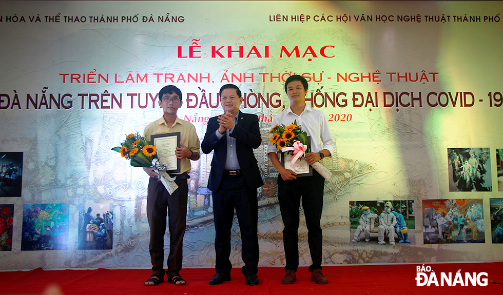Head of the municipal Party Committee’s Department of Publicity and Training Tran Dinh Hong (centre) and two first-prize winners