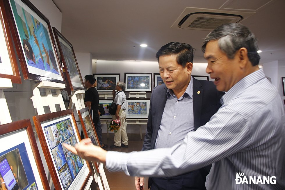 Head of the municipal Party Committee’s Department of Publicity and Training Tran Dinh Hong (2nd right) visiting the exhibition
