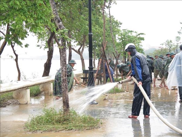 People clean up muds at Huong (Perfume) River in Thua Thien-Hue province after flooding (Photo: VNA)