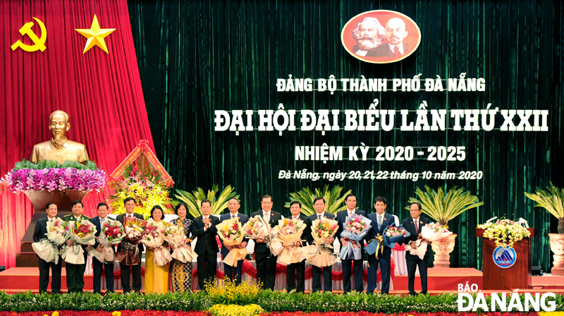 Bí thư Thành ủy khóa XXII Nguyễn Văn Quảng (thứ bảy, trái sang) tặng hoa cho các ủy viên Ban Chấp hành Đảng bộ thành phố khóa XXI không tái cử. Ảnh: ĐẶNG NỞ