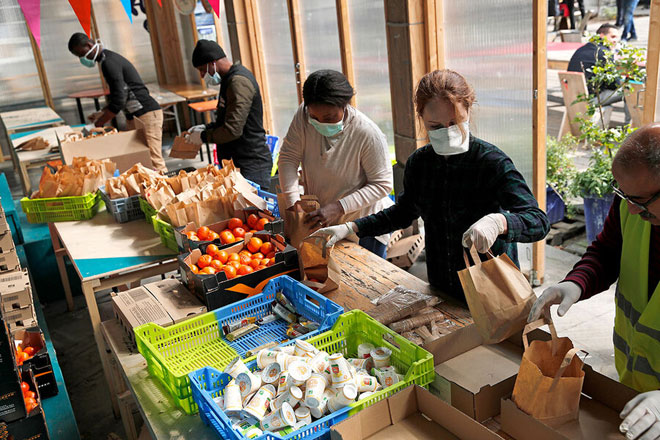 Các tình nguyện viên chuẩn bị những phần thức ăn để gửi đến Trung tâm Aurore cho những người vô gia cư và nhập cư ở thủ đô Paris của Pháp. Ảnh: AP