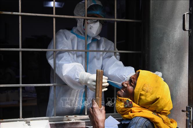 Nhân viên y tế lấy mẫu dịch COVID-19 cho người dân tại New Delhi, Ấn Độ. Ảnh: AFP/TTXVN