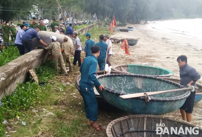 Các lực lượng chức năng đang khẩn trương giúp dân di chuyển thuyền, thúng lên bờ trú bão. Trong ảnh: Các lực lượng phường Thọ Quang (quận Sơn Trà) giúp ngư dân di chuyển thuyền, thúng lên bờ trú bão. Ảnh: HOÀNG HIỆP