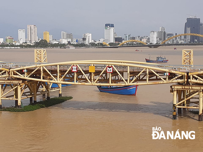 The middle span of the Nguyen Van Troi pedestrian bridge spanning the River Han in Da Nang being vertically lifted to allow fishing vessels to pass under to seek safe shelters from the storm