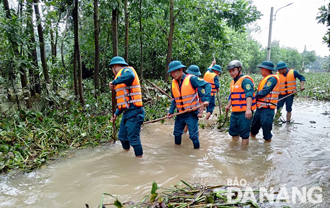 Dân quân huyện Hòa Vang giúp người dân khắc phục hậu quả mưa lũ sau cơn bão số 6 vừa qua.Ảnh: HỒNG HẠNH