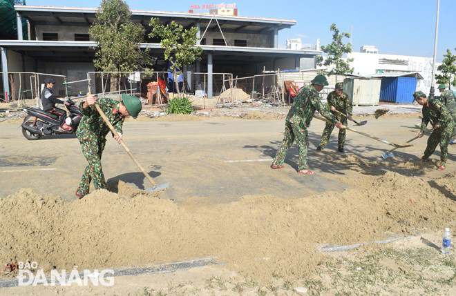 Trong sáng 29-10, hơn 200 cán bộ, chiến sĩ Ban Chỉ huy quân sự quận Sơn Trà, Vùng 3 Hải quân, Lữ đoàn 83 Hải quân, Đồn Biên phòng Sơn Trà thu dọn cát và rác trên đường Võ Nguyên Giáp, Hoàng Sa. Ảnh: HOÀNG HIỆP