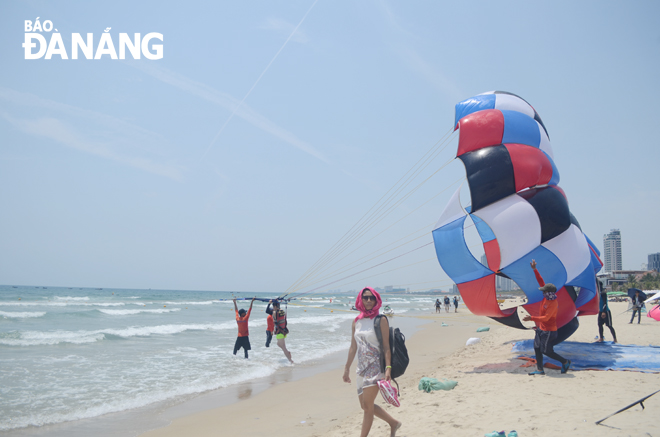 ourists experiencing parasailing on a beach in Da Nang