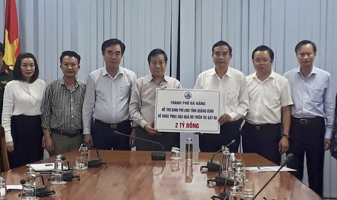 Da Nang Party Committee Deputy Secretary cum People's Committee Vice Chairman Le Trung Chinh (3rd right) giving financial aid to Quang Binh Province