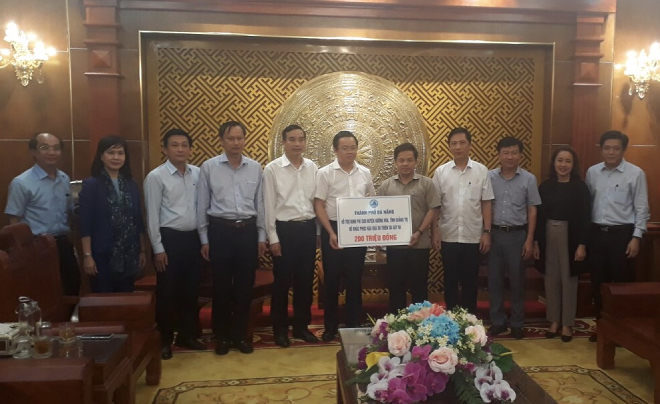 Da Nang People's Council Vice Chairman Le Minh Trung (6th left) offering 200 million VND to the Huong Hoa District authorities in Quang Tri Province