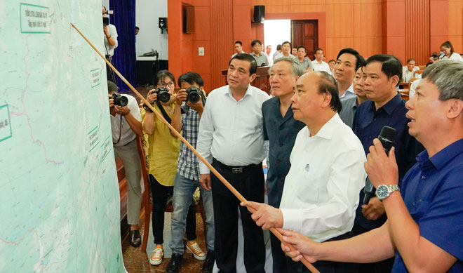 Thủ tướng Chính phủ Nguyễn Xuân Phúc xem bản đồ chỉ huy công tác tìm kiếm cứu nạn tại huyện Phước Sơn và Nam Trà My, tỉnh Quảng Nam. Ảnh: VGP