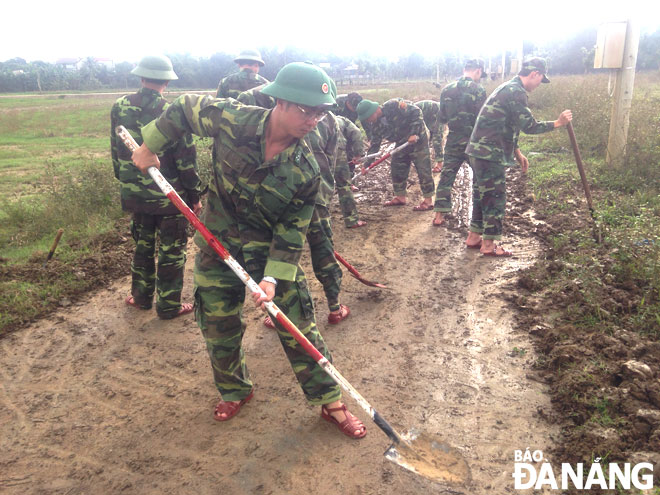 Đại úy Doãn Hồng Quang (đứng đầu hàng) cùng đồng đội dọn vệ sinh môi trường trên địa bàn quận Hải Châu. Ảnh: HỒNG QUANG