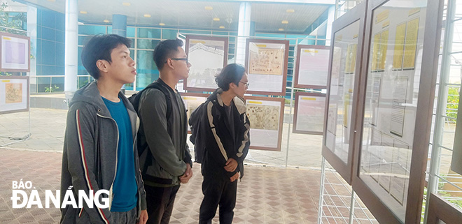 Da Nang students admiring valuable documents on display at the exhibition