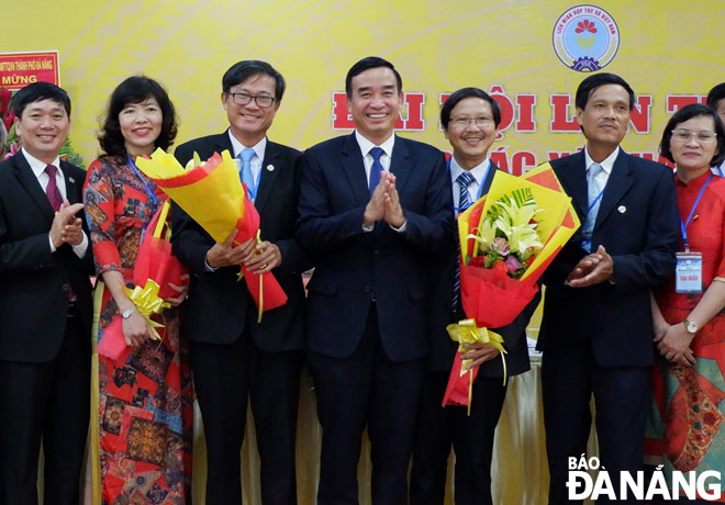 Phó Bí thư Thành ủy, Phó Chủ tịch Thường trực UBND thành phố Lê Trung Chinh (giữa) tặng hoa chúc mừng Ban Chấp hành Liên minh HTX thành phố nhiệm kỳ 2020-2025. Ảnh: HOÀNG HIỆP