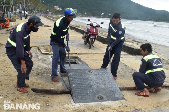 Công nhân của Công ty Thoát nước và Xử lý nước thải Đà Nẵng duy tu các cửa xả ven biển để sẵn sàng chống ngập úng. Ảnh: HOÀNG HIỆP