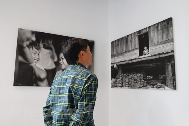 A man contemplating exhibited photos (Source: VNA)