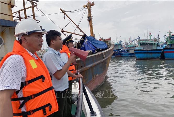 Lực lương chức năng kêu gọi tàu thuyền vào neo đậu tránh trú bão tại cảng cá Quy Nhơn (Bình Định). Ảnh: Nguyên Linh/TTXVN