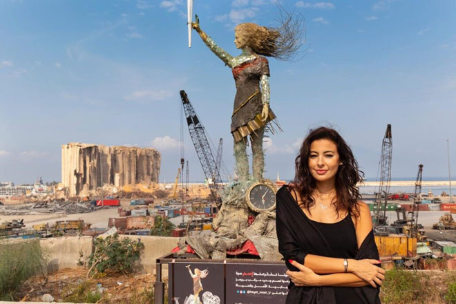 Hayat Nazer và tác phẩm điêu khắc được làm từ mảnh vỡ của vụ nổ cảng Beirut. Ảnh: CNN