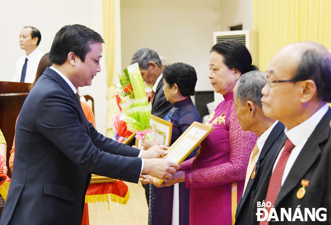Bí thư Huyện ủy Hòa Vang Phạm Nam Sơn (bìa trái) trao tặng Huy hiệu Đảng cho các thế hệ đảng viên. 			                                  Ảnh: ĐẶNG NỞ