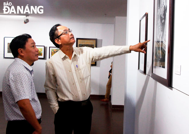 Visitors contemplating exhibited artworks