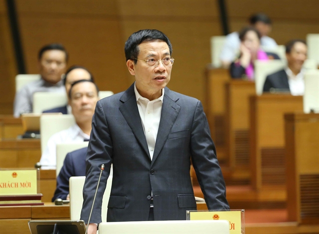 Minister of Information and Communications Nguyen Manh Hung answers questions from lawmakers during a National Assembly session on Friday in Hà Nội