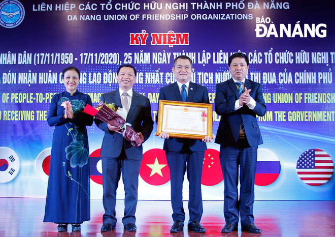 Authorised by the State President, President of the Viet Nam Union of Friendship Organisations (VUFO) Nguyen Phuong Nga (left) and Da Nang Party Committee Deputy Secretary Luong Nguyen Minh Triet (right) awarding the First-class Labour Medal to DAFO’s representatives