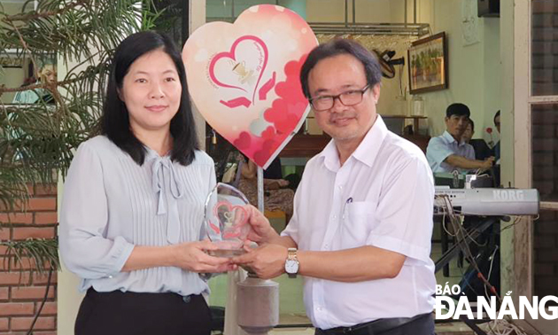 Vice Chairman of the municipal Journalists’ Association Hong Quang Nam (right) presenting a souvenir gift to Director of the municipal Department of Education and Training Le Thi Bich Thuan 