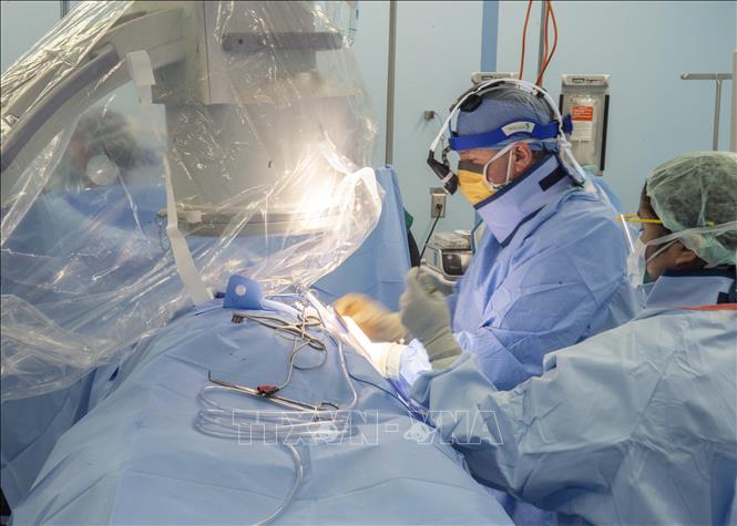 Nhân viên y tế điều trị cho bệnh nhân mắc COVID-19 trên tàu bệnh viện USNS Mercy ở Los Angeles, Mỹ. Ảnh: AFP/TTXVN