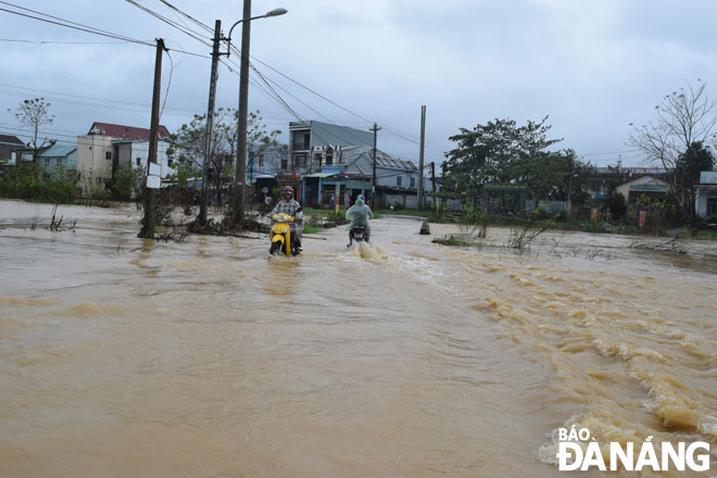 Nước lũ chảy xiết, tràn qua đường ĐH.409 (xã Hòa Tiến, huyện Hòa Vang) vào trưa 11-11.     			      Ảnh: H. HIỆP