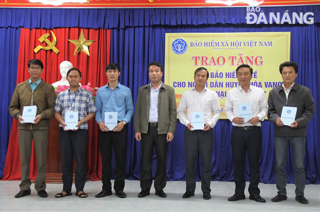 Tổng Giám đốc BHXH Việt Nam Nguyễn Thế Mạnh (giữa) trao thẻ bảo hiểm y tế cho đại diện các xã để cấp phát đến người dân. Ảnh: L.P