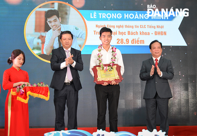 Municipal Party Committee Deputy Secretary Luong Nguyen Minh Triet (2nd, left) and UDN Director Assoc. Prof. PhD. Nguyen Ngoc Vu (right) honouring the UDN’s highest-achiever