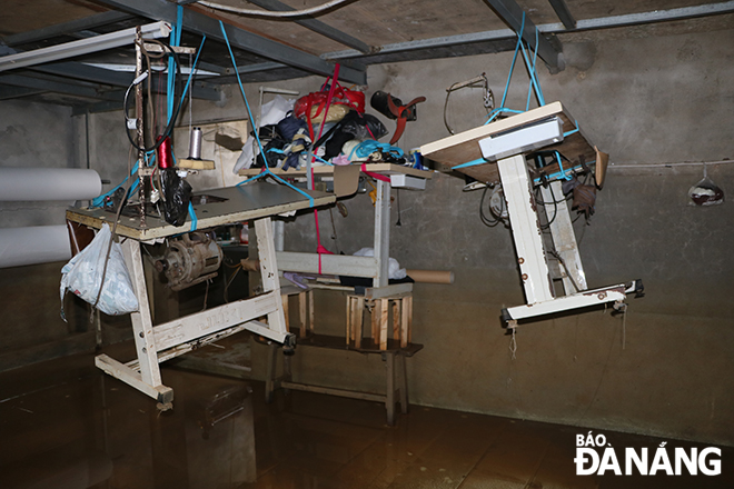 Bên trong một xưởng sản xuất tại thôn La Bông trong những ngày bị ngập nước. TRONG ẢNH: Những chiếc máy may được treo lên cao để hạn chế hư hỏng. Ảnh: MAI QUẾ.
