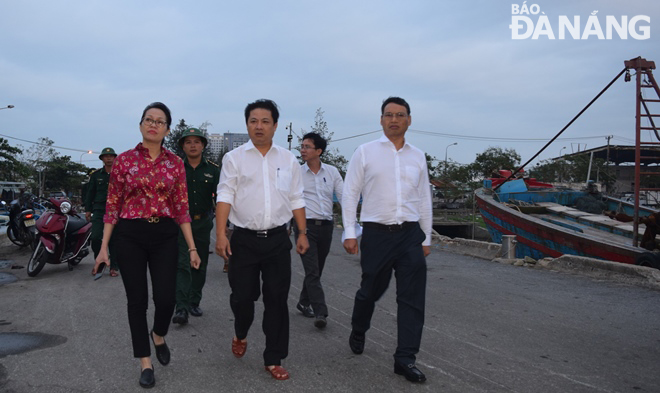 Phó Bí thư Thành ủy Lương Nguyễn Minh Triết (giữa) và Phó Chủ tịch UBND thành phố Hồ Kỳ Minh (bìa phải) kiểm tra thực tế công tác triển khai ứng phó bão số 13 tại tại âu thuyền và cảng cá Thọ Quang vào chiều tối 13-11. Ảnh: HOÀNG HIỆP