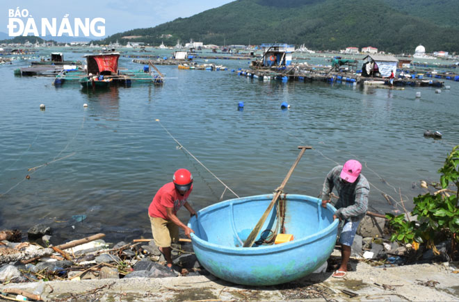 Người dân nuôi trồng thủy sản rời lồng bè, lên bờ trú bão vào trưa ngày 13-11. 	    Ảnh: HOÀNG HIỆP