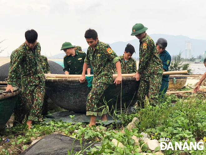 Cán bộ, chiến sĩ Đồn Biên phòng Phú Lộc đưa thuyền thúng của ngư dân về nơi tránh trú bão an toàn.
