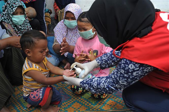 Người dân sát khuẩn tay phòng lây nhiễm COVID-19 tại khu trại tạm ở làng Stabelan, Boyolali, Trung Java, Indonesia, ngày 10/11/2020. Ảnh: THX/ TTXVN