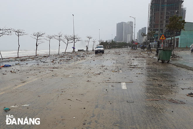 A lot of trash and sea sand washed onto the Vo Nguyen Giap-Hoang Sa Street by sea waves 