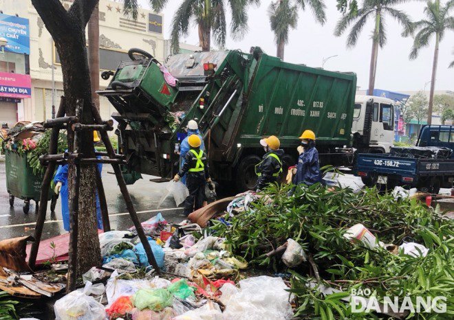 Công ty CP Môi trường Đô thị Đà Nẵng huy động nhân lực, phương tiện thu gom rác sinh hoạt và rác cành cây gãy đổ trên các tuyến đường chính. Ảnh: HOÀNG HIỆP