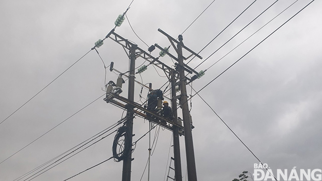 Các đơn vị điện lực trực thuộc EVNCPC đang tích cực triển khai công tác khắc phục hậu qua do cơn bão số 13 gây ra. Ảnh: KHÁNH HÒA