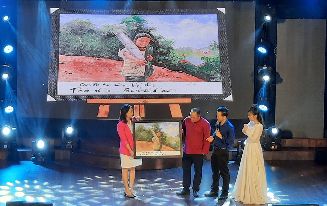 Bức ảnh chú bé miền núi Quảng Nam ôm bó rau núi, búp măng rừng tặng cho người Đà Nẵng trong thời gian Covid-19 được đấu giá tại chương trình. Trong ảnh: Người đấu giá cao nhất, 64 triệu đồng nhận bức tranh. Ảnh: XUÂN DŨNG