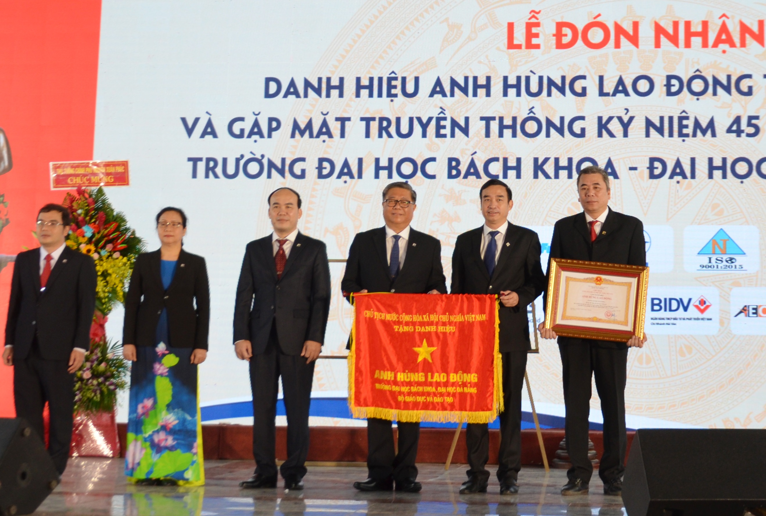 Da Nang People’s Committee Vice Chairman Le Trung Chinh (2nd right) handing State President’s ‘Labour Hero’ title to DUT’s leaders