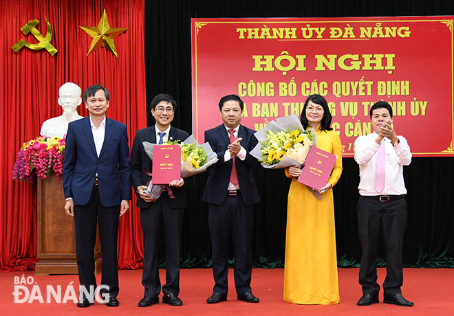 Phó Bí thư Thường trực Thành ủy Lương Nguyễn Minh Triết (giữa) trao các quyết định và tặng hoa chúc mừng các cá nhân. Ảnh: ĐẶNG NỞ