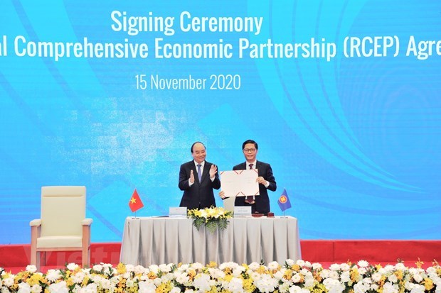 Vietnamese Prime Minister Nguyen Xuan Phuc (R) and Minister of Industry and Trade Tran Tuan Anh at signing ceremony of RCEP (Source: VNA)