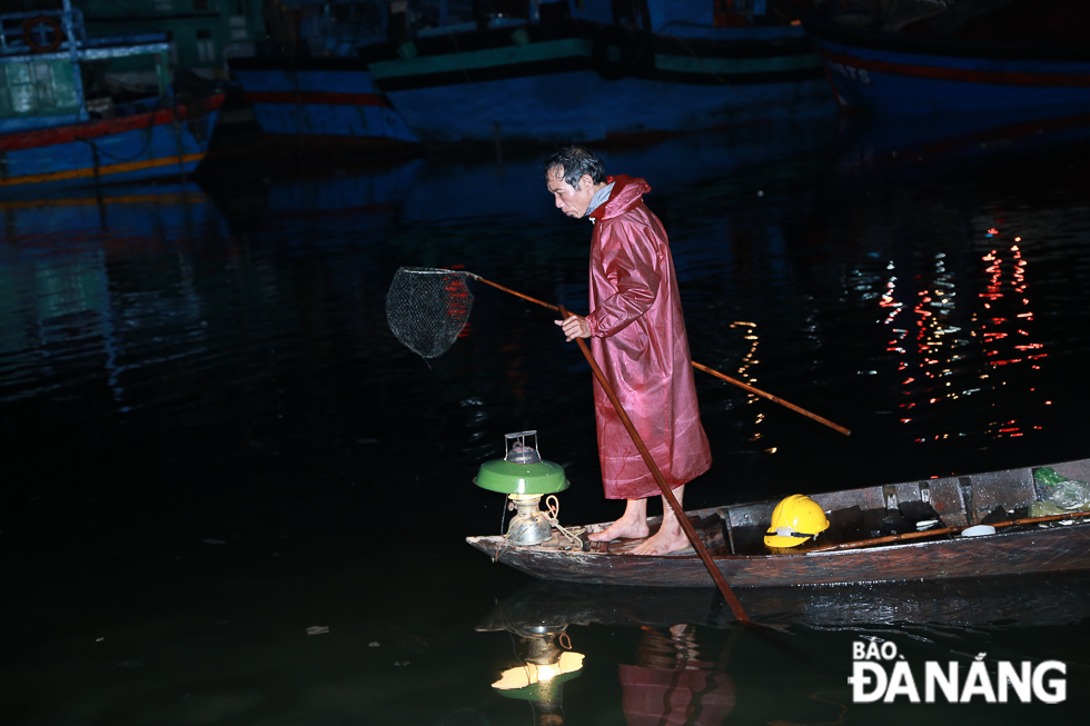 A Tho Quang fisherman is catching fish at night to make ends meet