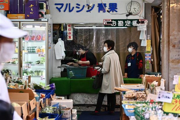 Người dân đeo khẩu trang phòng lây nhiễm COVID-19 tại một cửa hàng ở Tokyo, Nhật Bản (Ảnh: AFP/TTXVN)