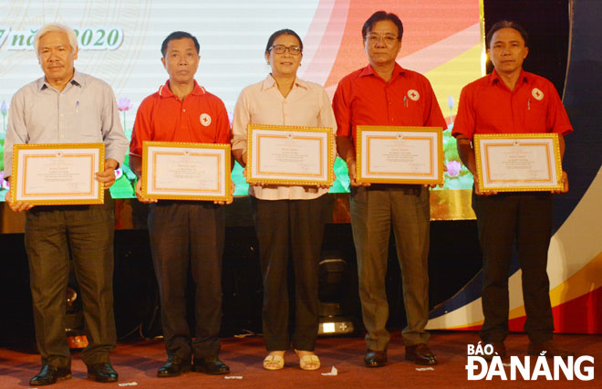 Ông Nguyễn Tấn Hùng (bìa phải) nhận bằng khen của Trung ương Hội Chữ thập đỏ Việt Nam. Ảnh: LÊ VĂN THƠM