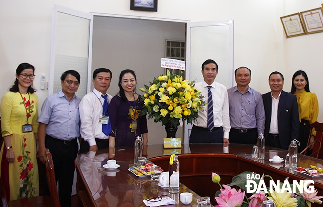 Municipal Party Committee Deputy Secretary cum municipal People's Committee Vice Chairman Le Trung Chinh (4th right) presenting flowers to representatives from the city’s Junior College of Culture and Arts