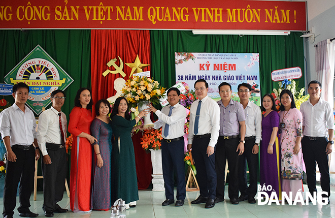 Municipal People's Council Chairman Nguyen Nho Trung (7th right) presenting flowers to teaching staff of the Tran Dai Nghia Primary School