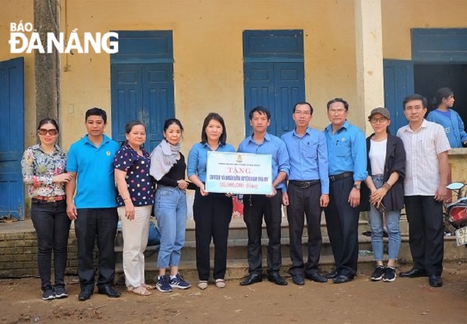 Chủ tịch Công đoàn Viên chức thành phố Nguyễn Thị Dung (thứ 5, trái sang) trao kinh phí hỗ trợ cho cán bộ công chức, người lao động và nhân dân huyện Nam Trà My (tỉnh Quảng Nam) gặp thiệt hại do bão lũ. Ảnh: CĐVC