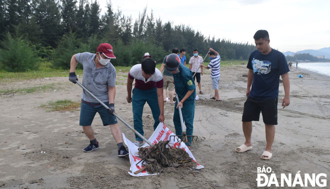 Người dân quận Thanh Khê thu gom rác tấp vào bãi biển dọc tuyến đường Nguyễn Tất Thành.