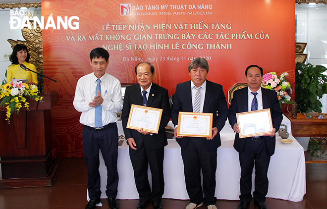 Director of the Da Nang Department of Culture and Sports Huynh Van Hung (left) presenting certificates to artisans who donated artifacts to the Da Nang Museum of Fine Arts